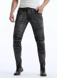 Detail of grey biker jeans showing articulated pleated knees and stonewashed texture
