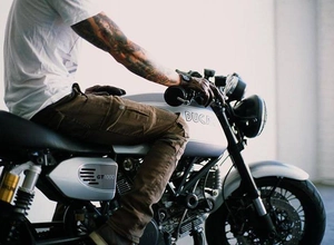 Detail view of brown motorcycle riding pants with accordion stretch panels on the knee