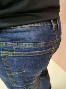 Détail du jean de moto bleu foncé avec coutures jaunes contrastées et poches à la taille
