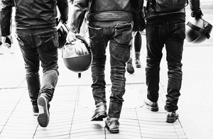 Black and white back view of a retro motorcycle riding gear set with slim denim pants