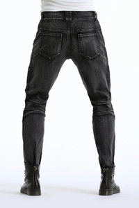 Detailed back view of motorcycle jeans featuring protective accordion ribbing and washed grey denim