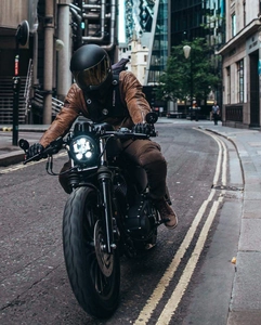 Close-up of brown vintage leather motorcycle jacket worn during a street ride in the city