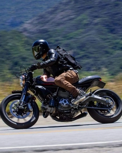 Action shot of black protective motorcycle riding gear and jacket on a bike