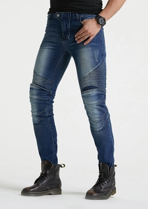 Détail des empiècements en accordéon aux genoux sur jean de moto bleu délavé