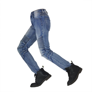 Détail latéral du jean de moto bleu clair avec panneaux extensibles aux genoux et bottines