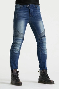 Détails du jean moto montrant les plis en accordéon aux genoux et la texture du denim