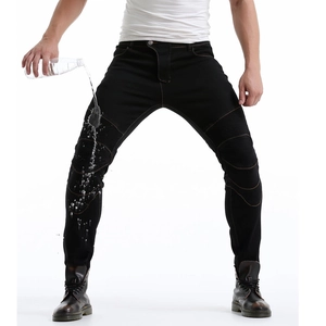 Waterproof detail of black motorcycling jeans showing water droplets on the fabric surface