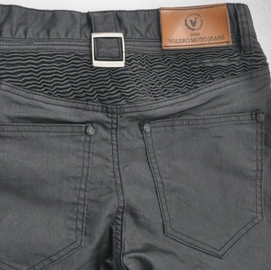Detail view of the elastic accordion panels and leather logo on motorcycle riding jeans