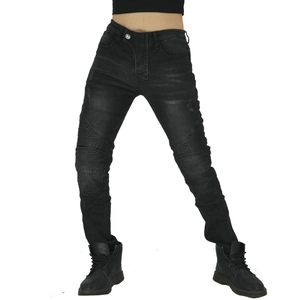 Détail d'un jean moto slim avec empiècements plissés aux genoux et texture denim délavé
