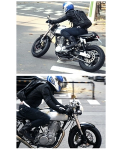 Rear view of a rider wearing a black leather aerodynamic motorcycle backpack on a city street