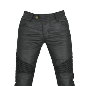 Detail of waterproof coated motorcycle jeans with accordion pleats on knees and metal button