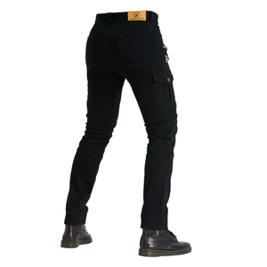 Detail of motorcycle jeans featuring yellow leather brand label and protective ribbed panel