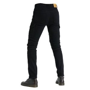 Detail of black motorcycle riding jeans showing elastic accordion panels and a leather patch