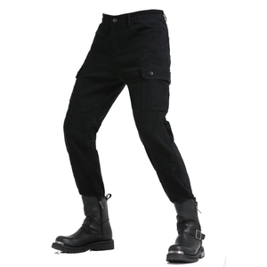 Detail view of black cargo motorcycle pants with large side pockets and metal-toe boots