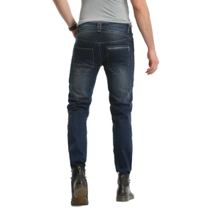 Detail of dark blue moto-style jeans with back waist pleats and metal zipper design