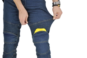Detail showing the placement of yellow knee armor pads in motorcycle riding jeans