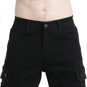Detailed view of the waist, metal button fly, and belt loops on black cargo moto pants