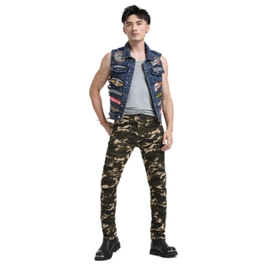 Full body view of camo motorcycle pants paired with a denim vest and tactical boots