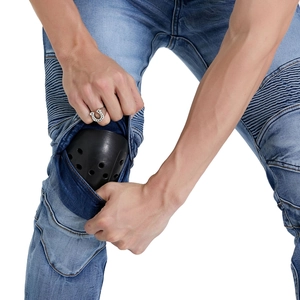 Close-up of protective knee pads and stretch accordion panels on blue motorcycle jeans