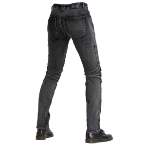 Macro detail of the stretch accordion panels and leather logo on black motorcycle jeans