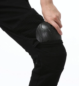 Detail of protective knee pads being inserted into black motorcycle riding pants