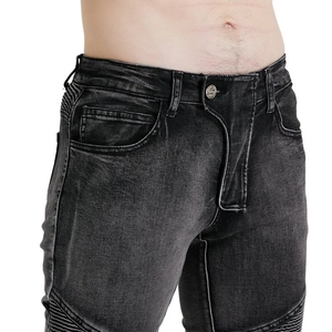 Detail of vintage moto-style jeans with distressed wash and accordion stretch panels
