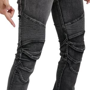 Detail view of motorcycle jeans featuring biker pleats and washed denim texture