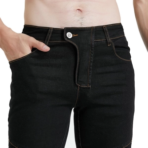Detail of motorcycle jeans showing orange stitching and embossed metal button on waist