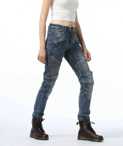 Detail of blue moto jeans showing ribbed pleated panels on knees and side zipper accents