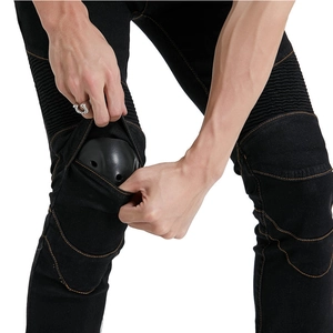 Detail of motorcycle jeans showing orange stitching and removable knee protection pad
