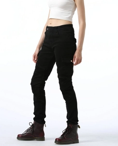 Detail view of black moto riding pants featuring side cargo pockets and pleated knee panels