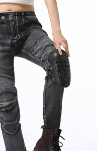 Detail of professional black motorcycle knee pads installed on grey washed riding jeans