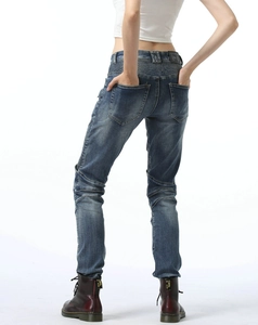 Detail of accordion stretch panels and leather brand patch on blue biker jeans