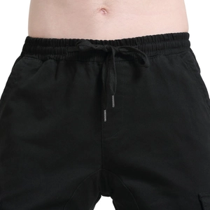 Detail of black motorcycle riding pants featuring an elastic drawstring waist and metal tips