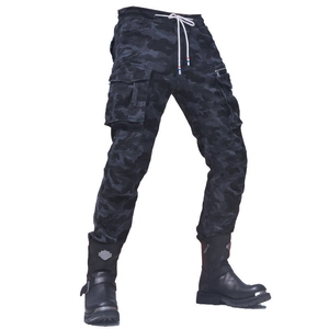 Macro view of black camouflage motorcycle pants with tactical cargo pockets and boots