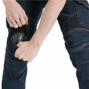 Detail showing the installation of removable knee protectors in green cargo motorcycle pants