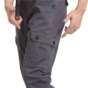 Close-up of large flap pockets with double button detail on men's dark grey cargo pants