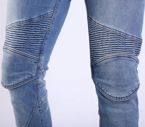 Close-up of light blue motorcycle jeans with biker-style knee pleats and twill texture