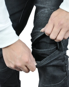 Detail of pleated knee design and protective pocket on black biker denim pants