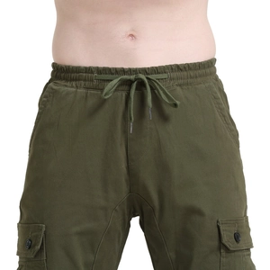 Detail of army green cargo pants featuring drawstring waist and large utility pockets