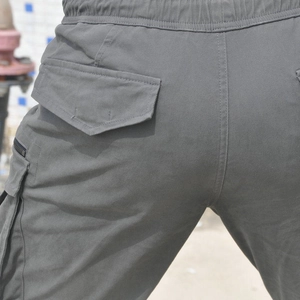 Macro shot of durable cotton cargo pants showing tactical back pockets and drawstring waist