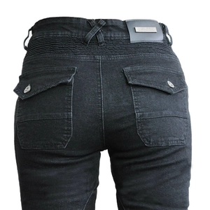 Dettaglio jeans da moto con inserti elasticizzati a soffietto e placca logo metallica