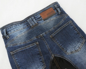 Detail of motorcycle jeans showing accordion stretch panels and leather logo patch