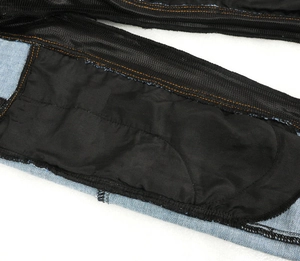 Detail of the high-waisted motorcycle jeans with black elastic mesh lining and orange stitching