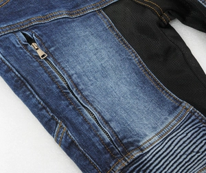 Detail of blue denim motorcycle jeans with mesh panels and yellow stitching