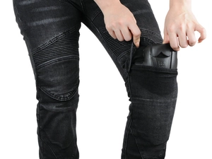 Detail of inserting protective knee pads into black washed motorcycle denim pants