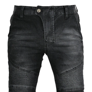 Close-up of black biker denim jeans with ribbed knee panels and metal button waist