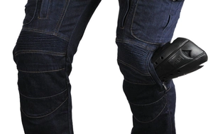Detail of blue motorcycle jeans featuring protective armor pad and accordion panels