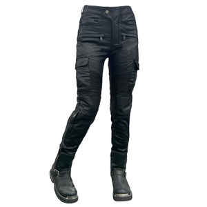 Close-up of waterproof motorcycle pants featuring knee accordion panels and utility pockets