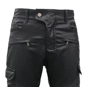Detail of motorcycle cargo pants featuring leather texture and metallic logo button